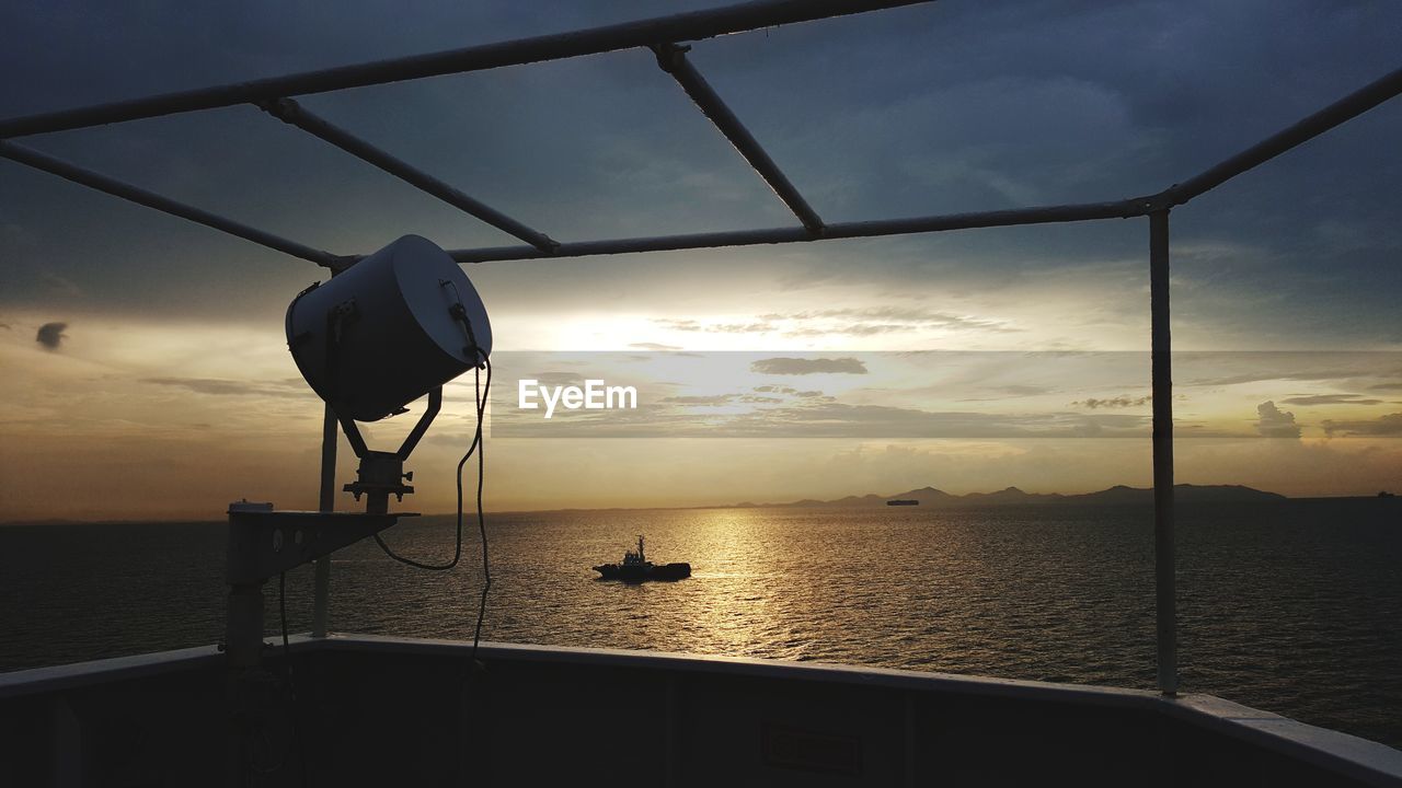 SILHOUETTE BOAT AGAINST SEA DURING SUNSET