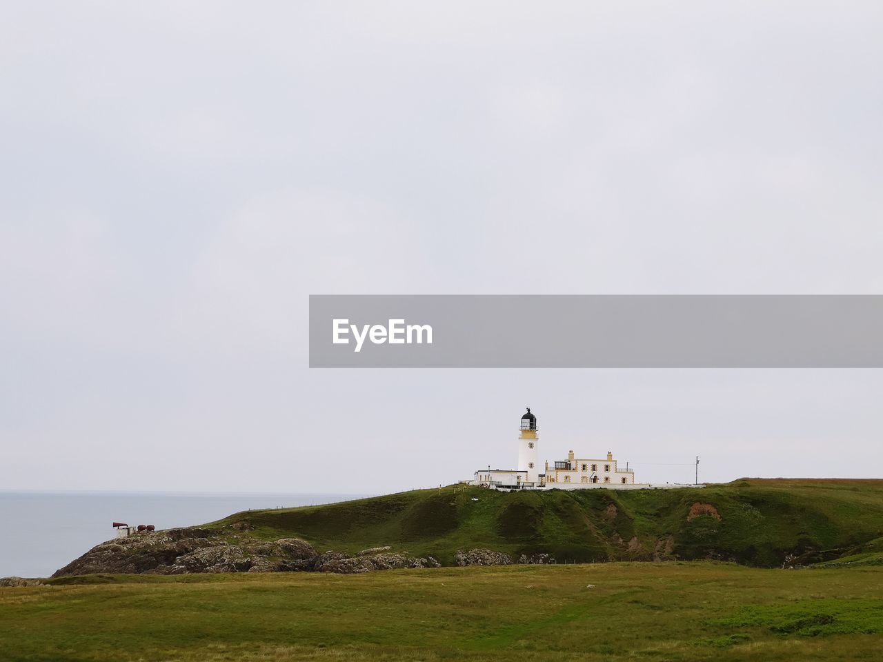 LIGHTHOUSE AMIDST SEA AGAINST SKY