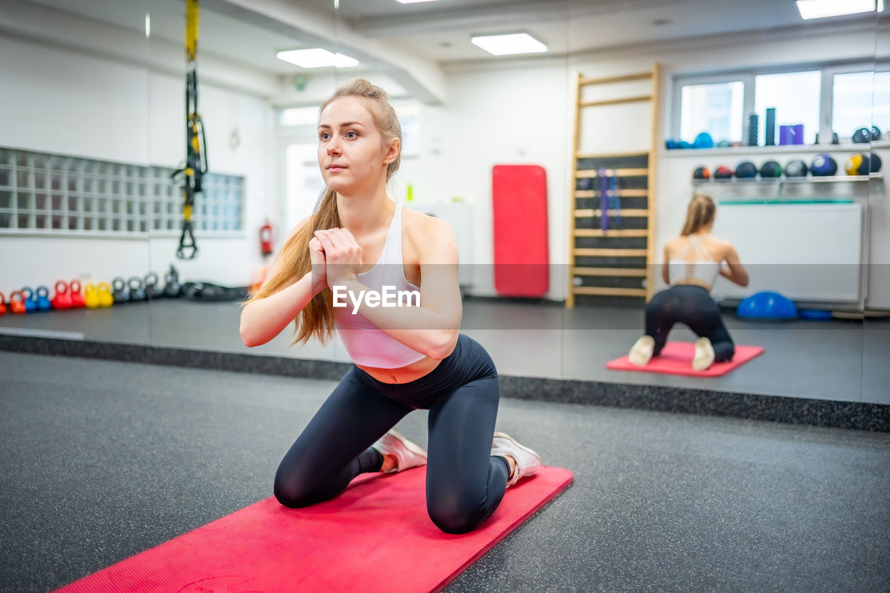 full length of woman exercising in gym