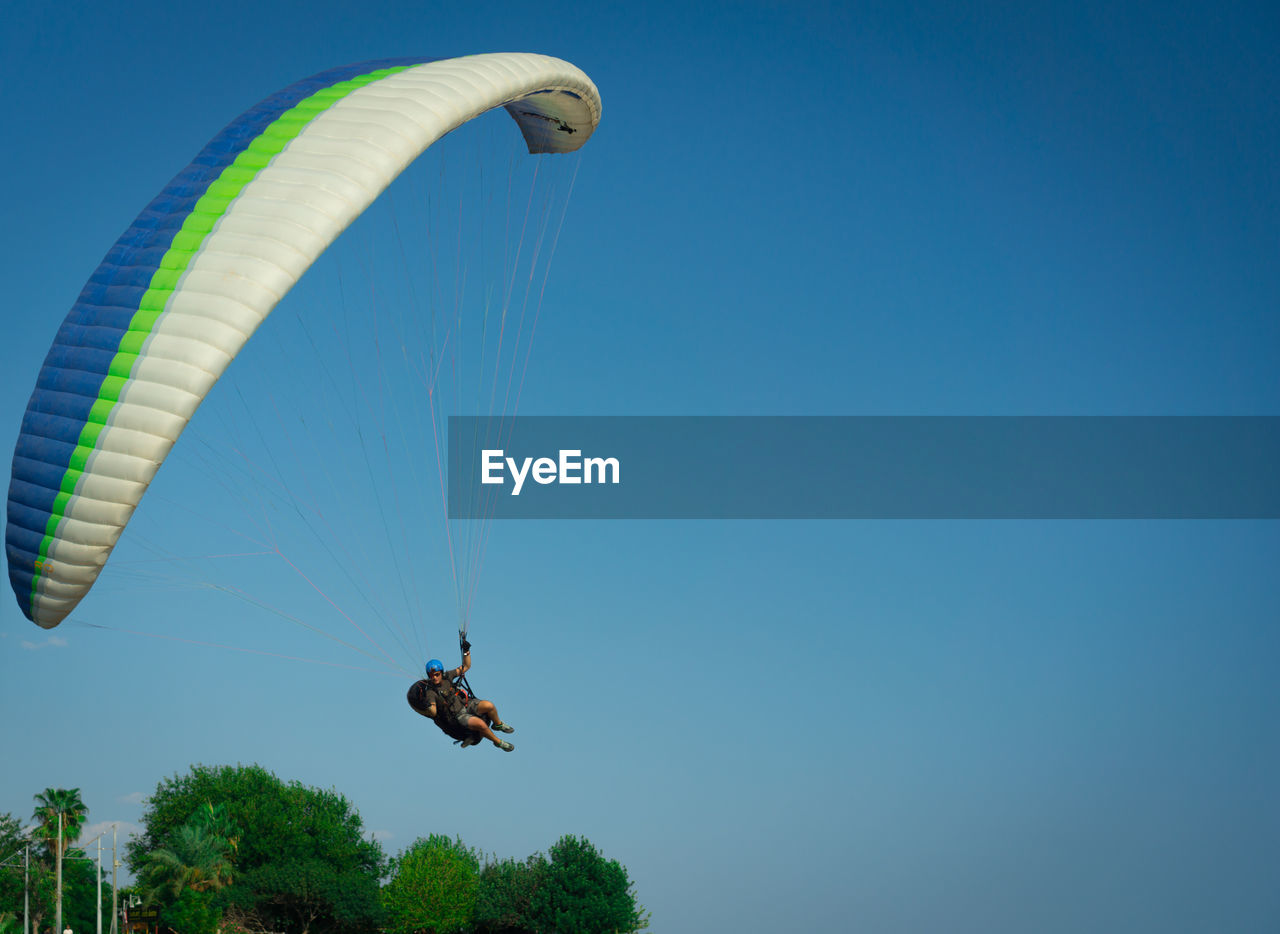 LOW ANGLE VIEW OF PERSON FLYING IN SKY