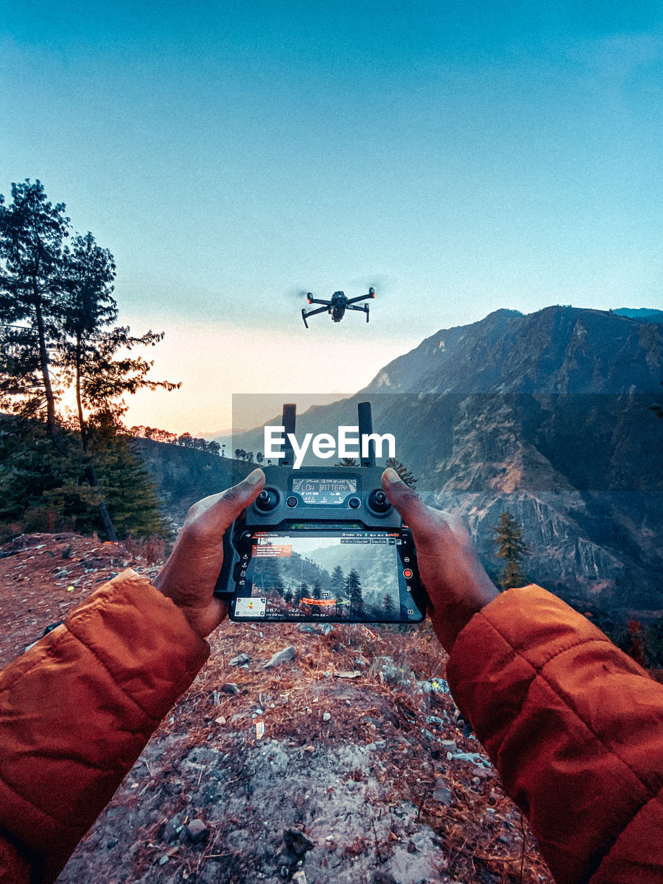 AIRPLANE FLYING OVER MOUNTAINS AGAINST SKY