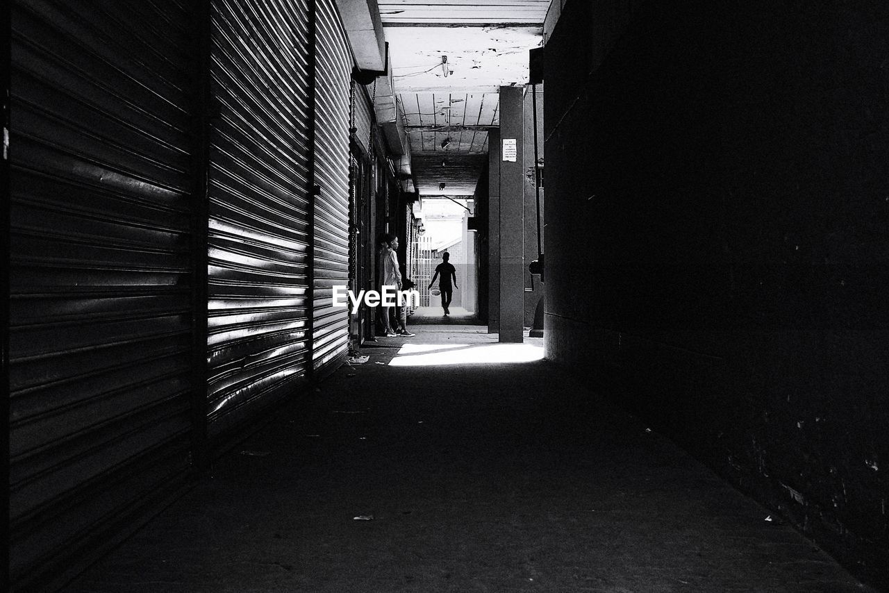 PEOPLE WALKING ON FOOTPATH AMIDST BUILDINGS IN CITY