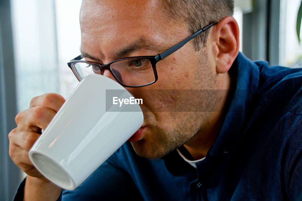 Close-up of man drinking milk from cup