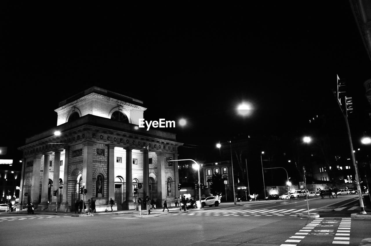 Illuminated historic building on street against clear sky at night