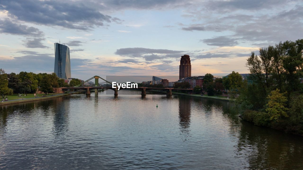 BRIDGE OVER RIVER WITH CITY IN BACKGROUND