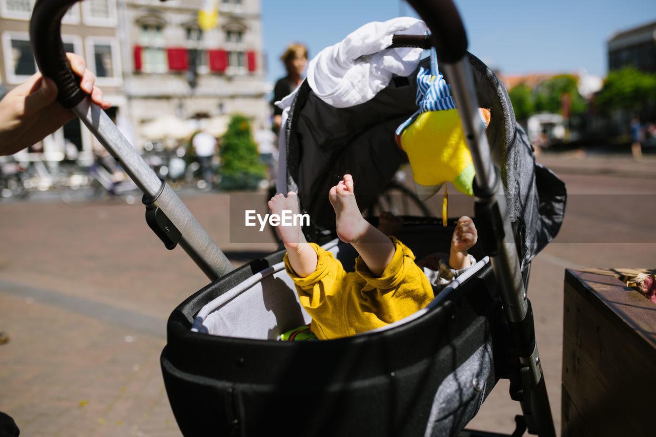 Cropped image of parent pulling baby stroller