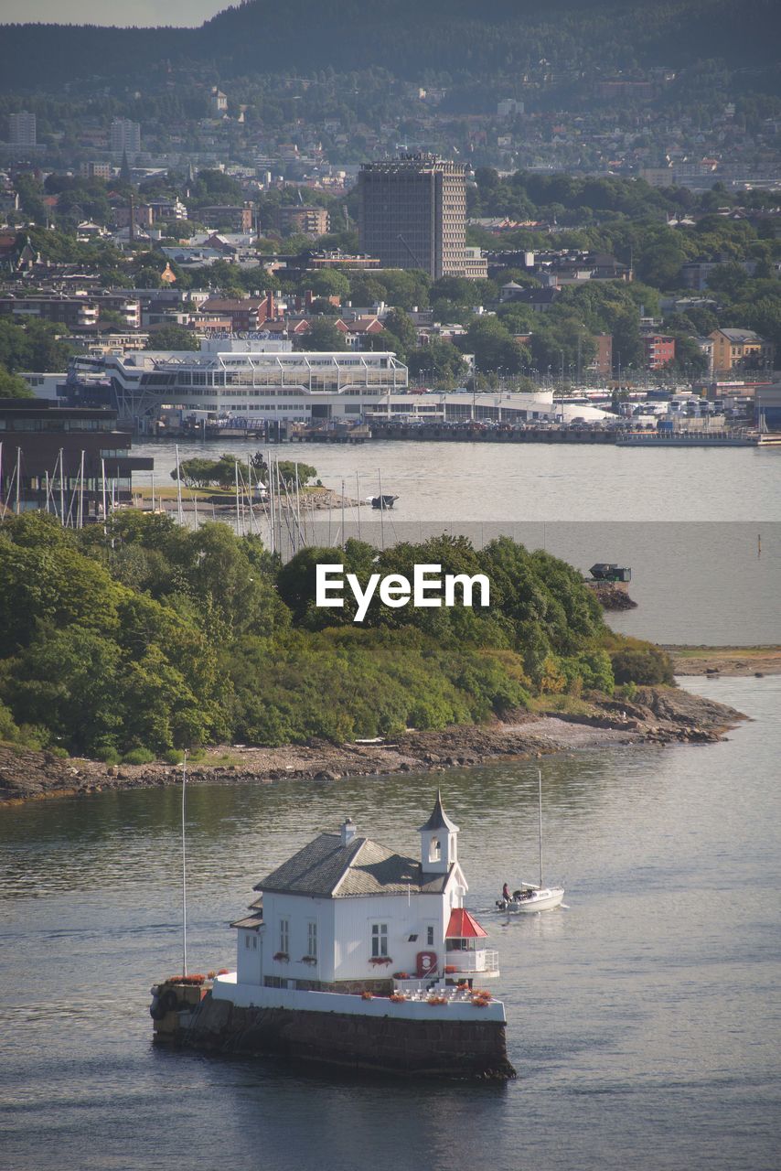 Sailboats in sea by buildings in city