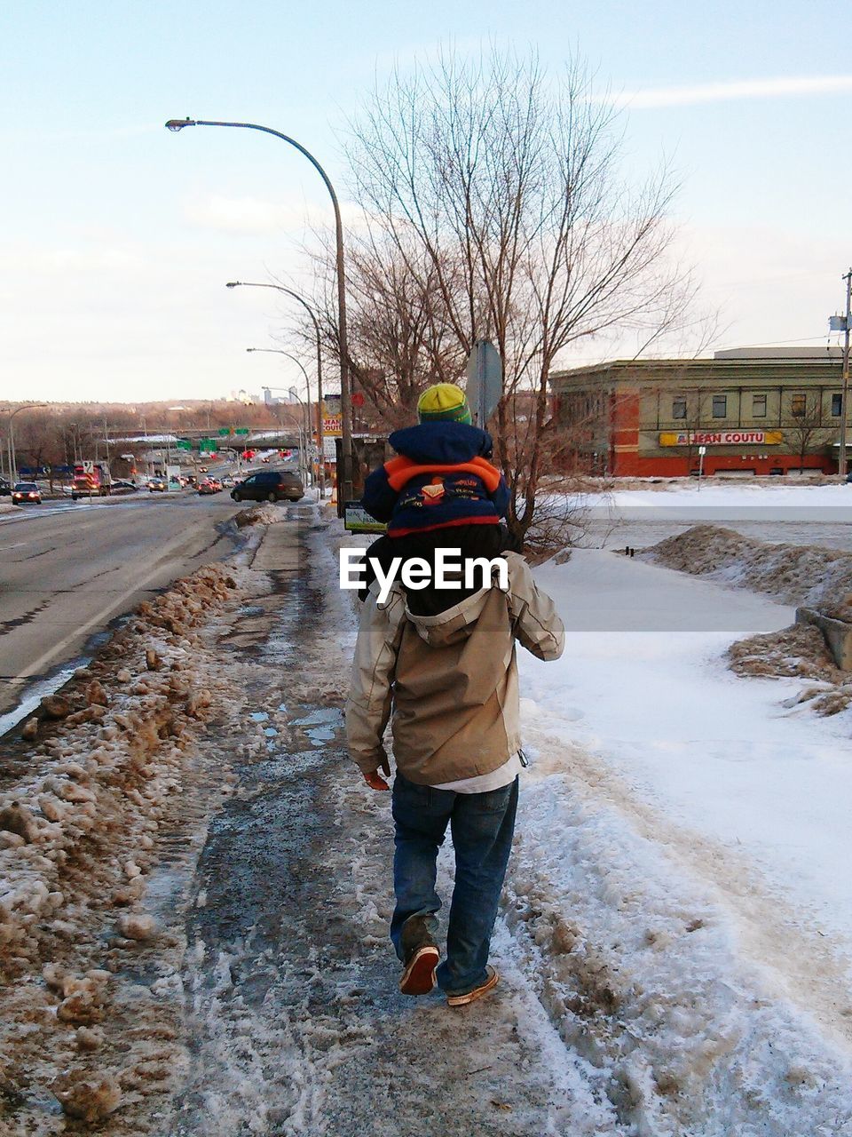 WOMAN WALKING ON SNOW COVERED ROAD