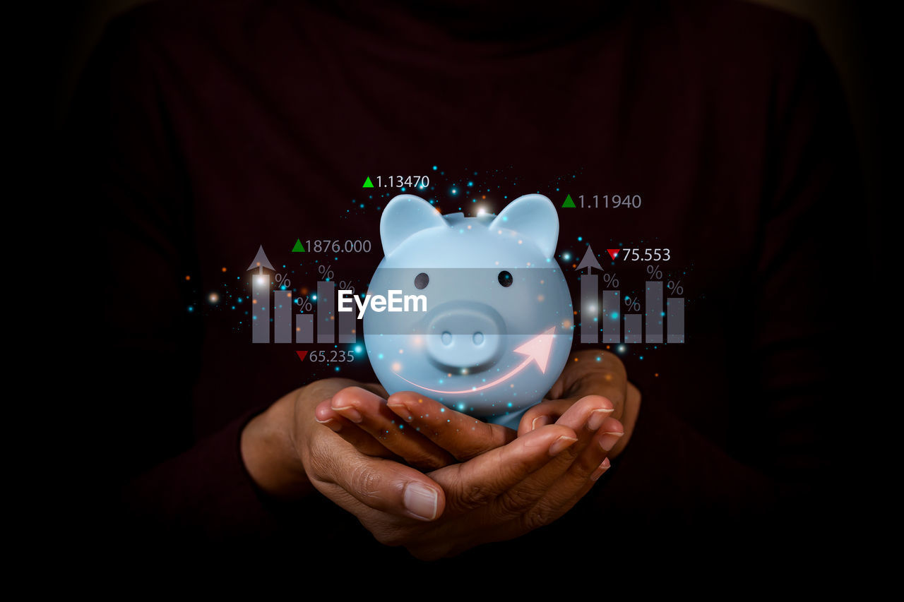 finance, savings, investment, piggy bank, one person, holding, business, currency, hand, indoors, front view, wealth, studio shot, adult, pig, black background, screenshot, copy space