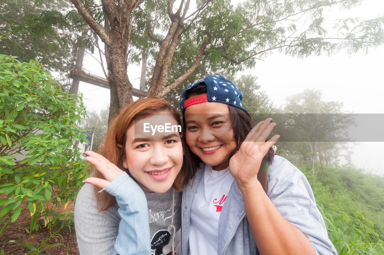 PORTRAIT OF SMILING YOUNG COUPLE ON FIELD