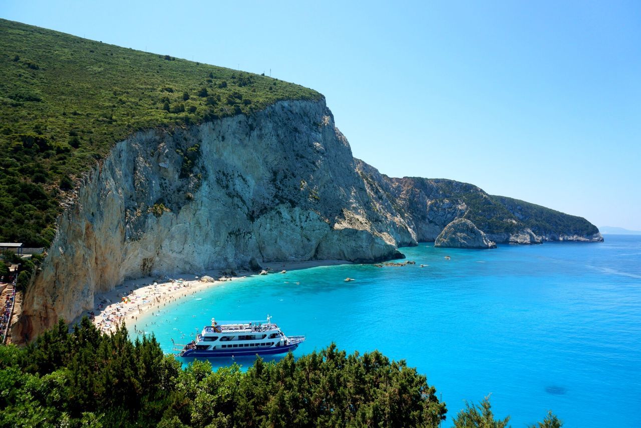 High angle view of nautical vessel on sea by mountain against sky