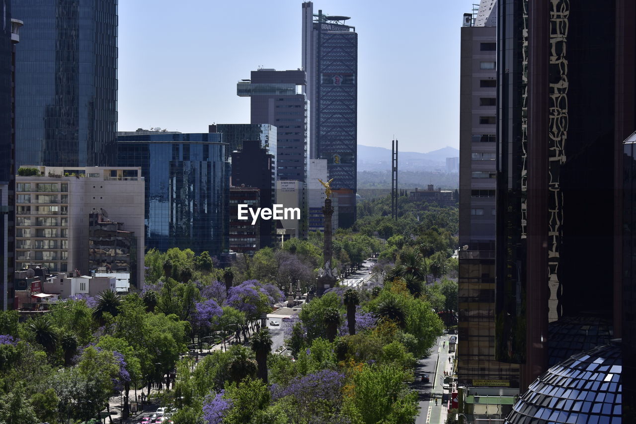 High angle view of modern buildings against clear sky in city during sunny day