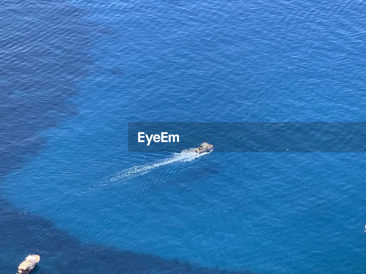 HIGH ANGLE VIEW OF SAILBOAT SAILING ON SEA