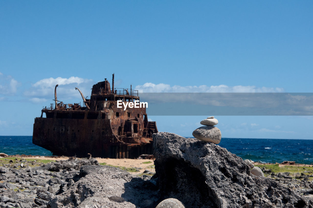 sea, sky, water, coast, ocean, nature, rock, ship, beach, nautical vessel, land, transportation, shore, shipwreck, blue, cliff, history, travel destinations, terrain, architecture, the past, travel, vacation, mode of transportation, no people, vehicle, day, outdoors, scenics - nature, cloud, tower, horizon over water, bay, abandoned, ruined, coastline, old, built structure, horizon, old ruin, clear sky