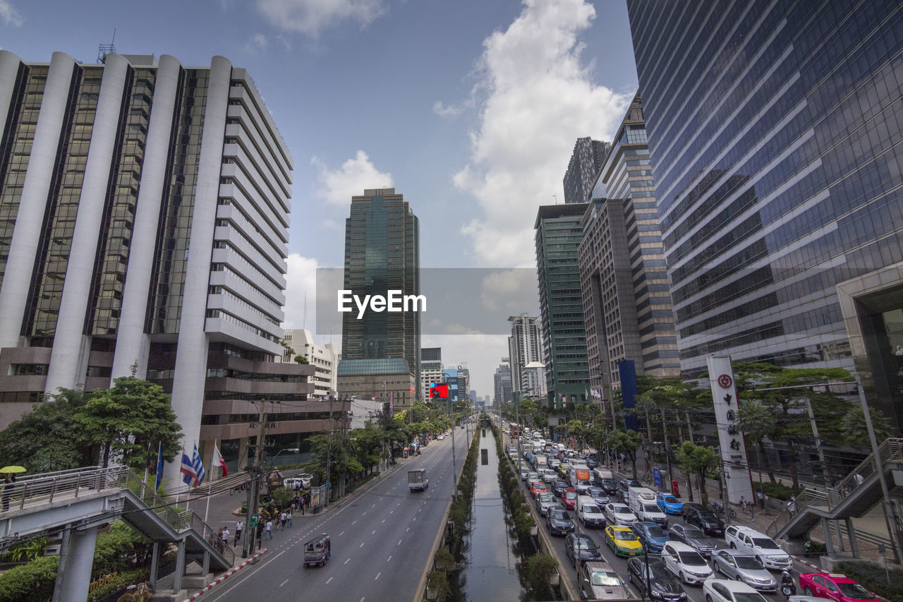 PANORAMIC VIEW OF CITY STREET AND MODERN BUILDINGS AGAINST SKY