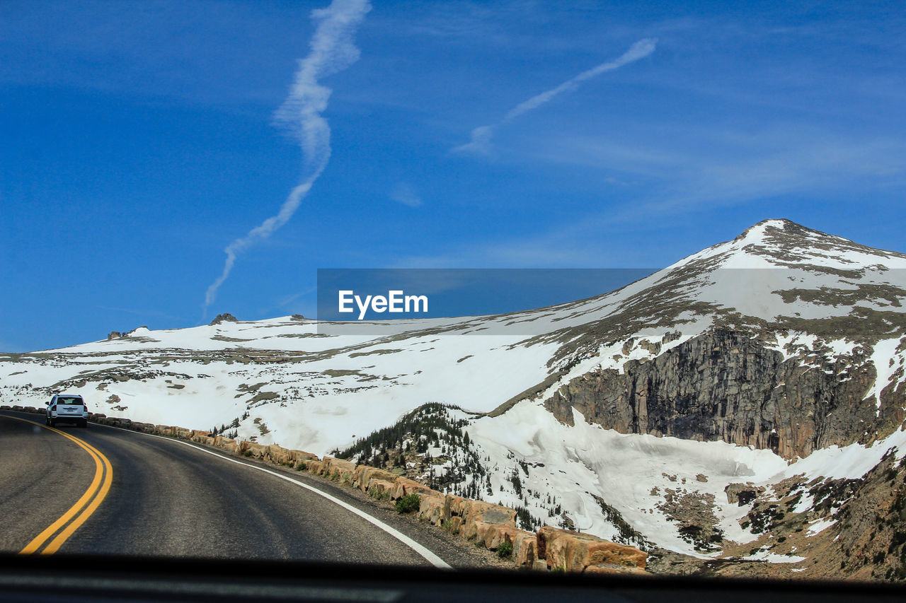 Scenic view of snowcapped mountains against blue sky