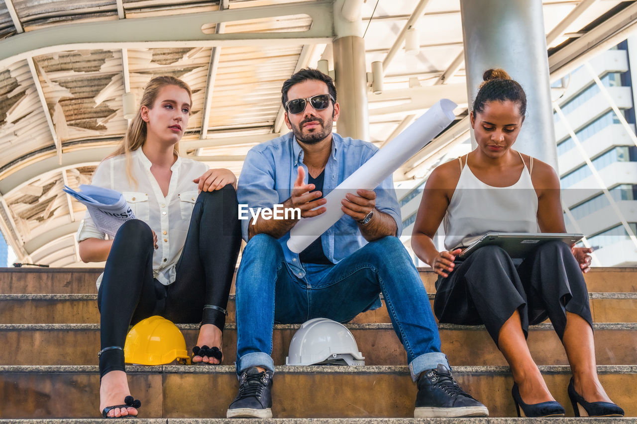 YOUNG COUPLE SITTING ON A MAN