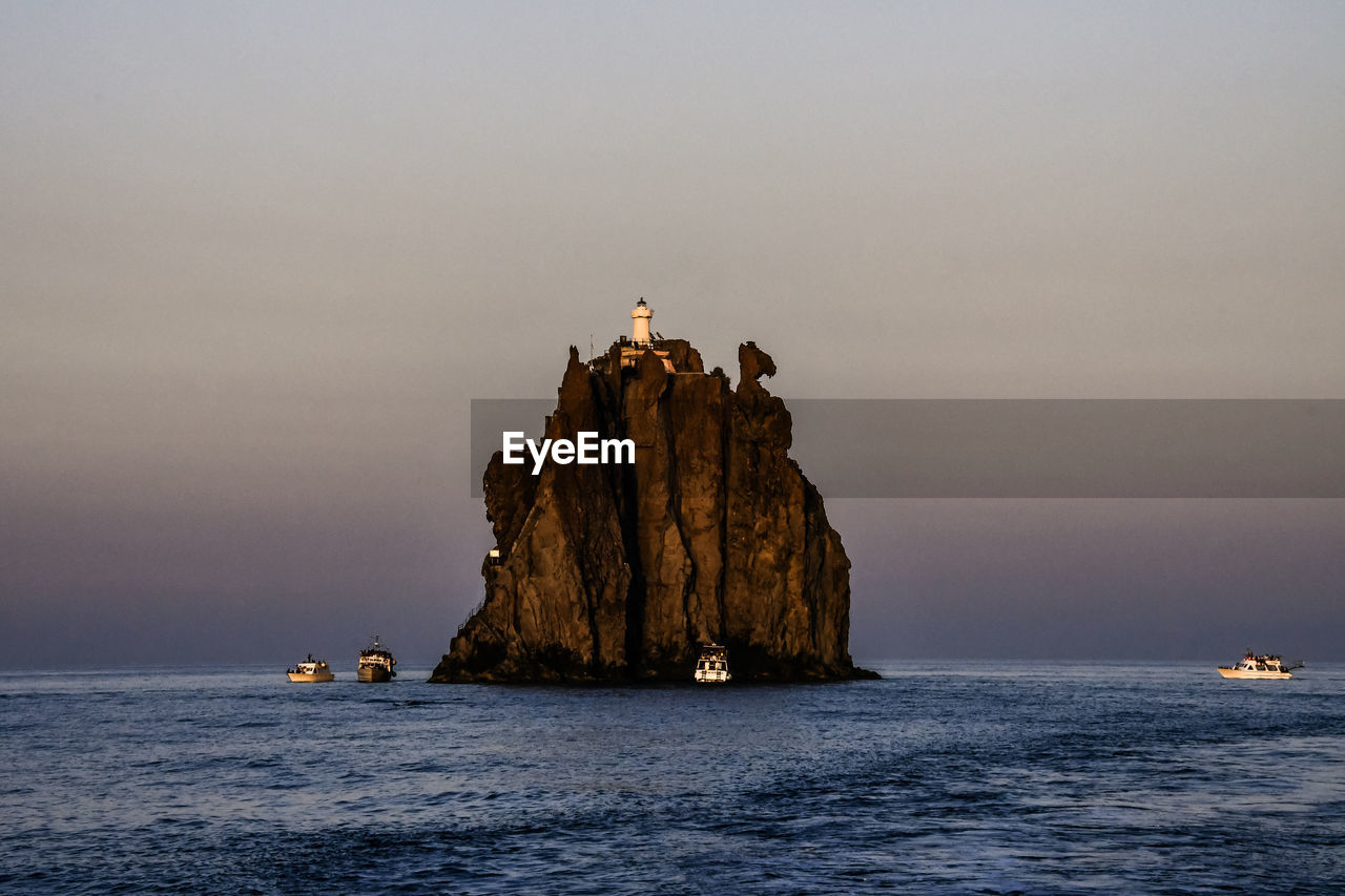 ROCK FORMATIONS IN SEA AGAINST SKY