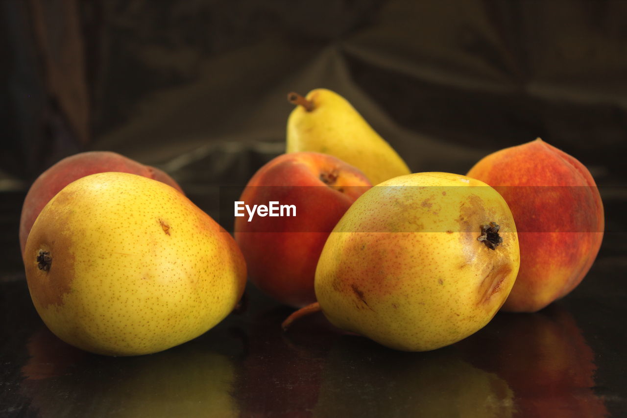 One yellow autumn pear on a black background