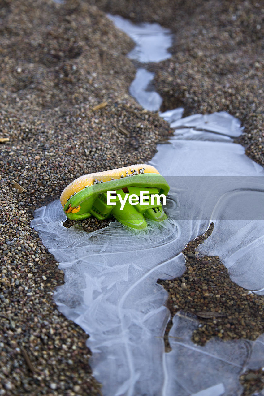 High angle view of toy boat with ice on field