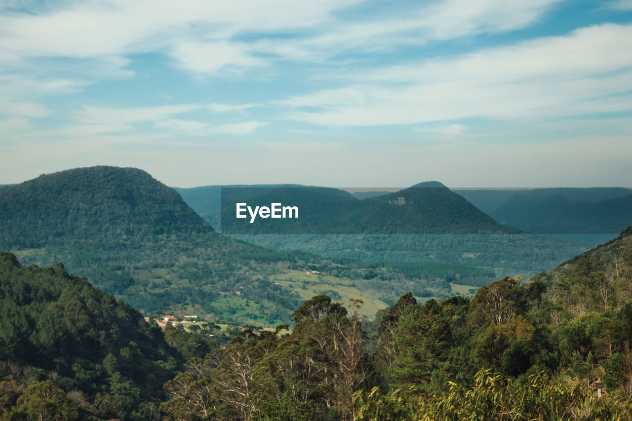 Rural landscape of a valley with hills covered by forests in the foreground near canela, brazil.