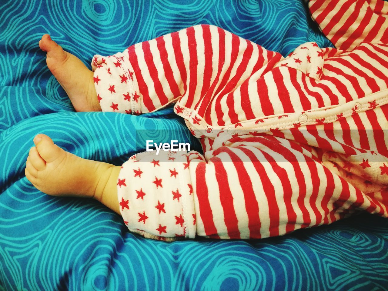 Low section of a toddler lying in bed