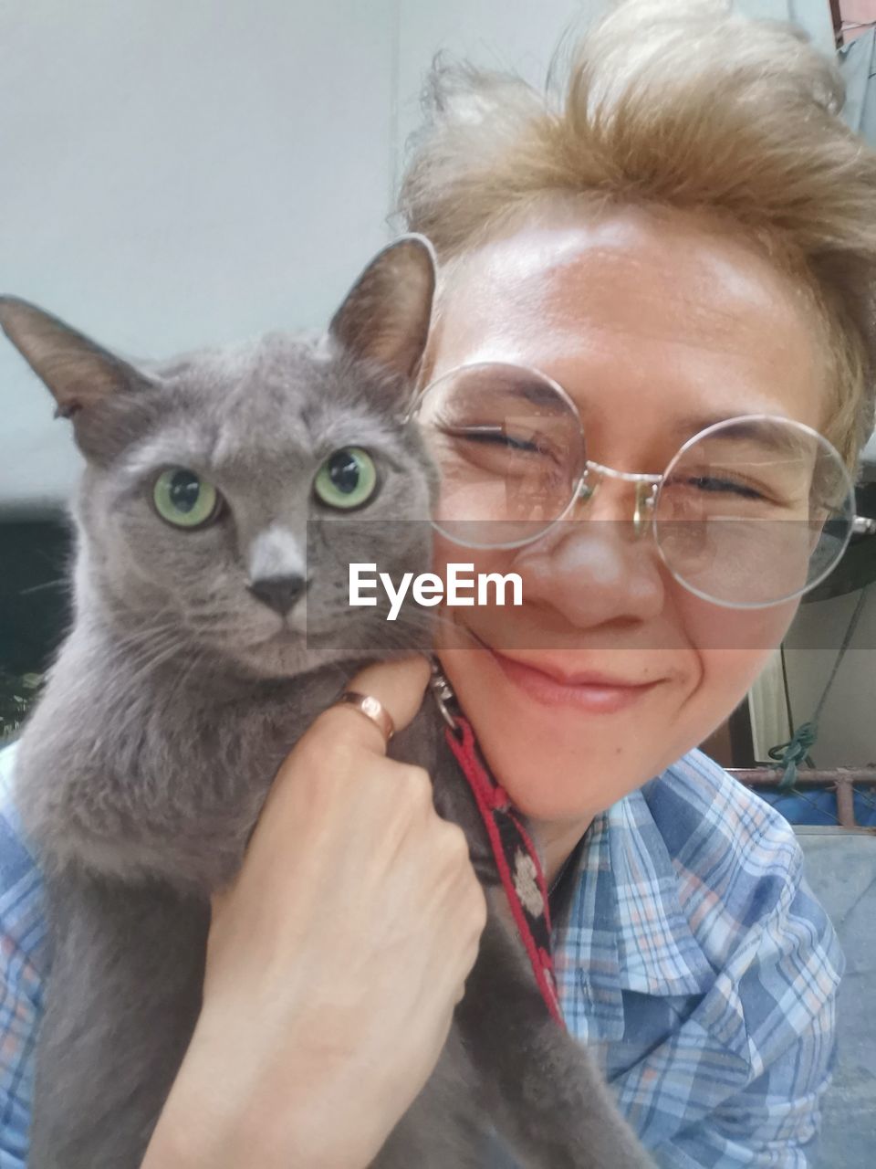 PORTRAIT OF SMILING YOUNG WOMAN WITH CAT WITH EYES