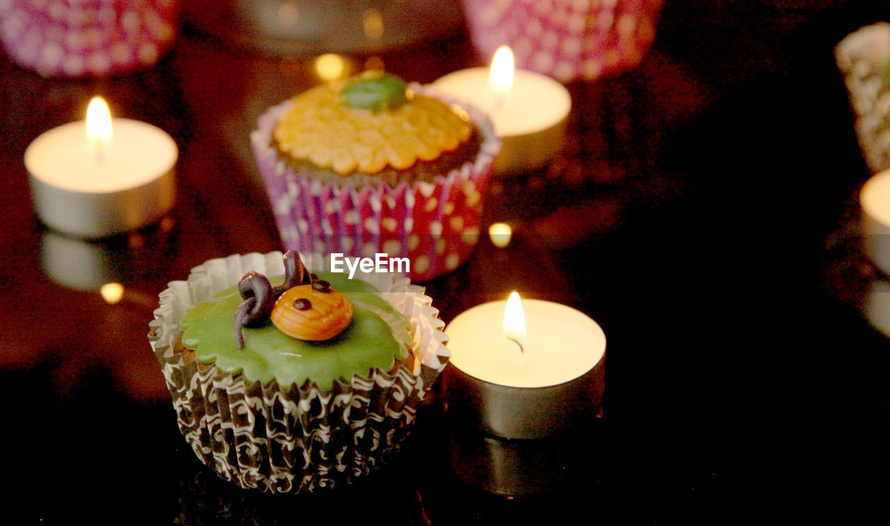 Close-up of halloween cupcakes and candles on table