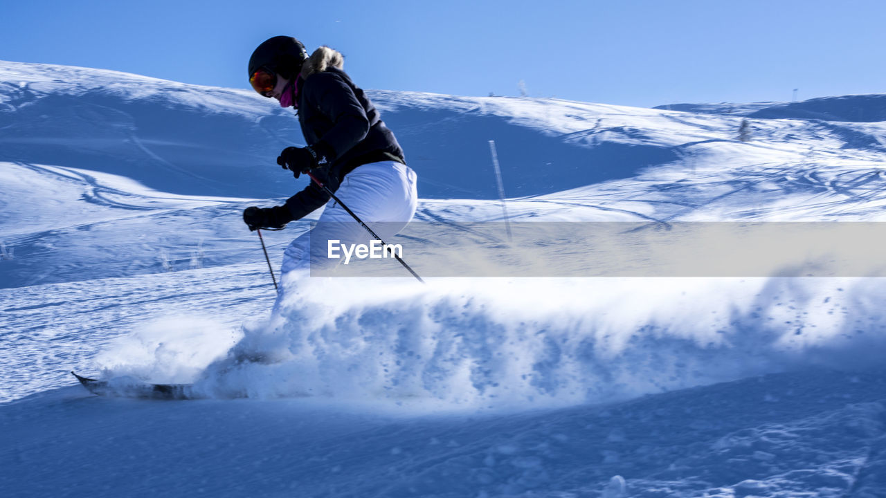 MAN SKIING ON SNOWCAPPED MOUNTAINS