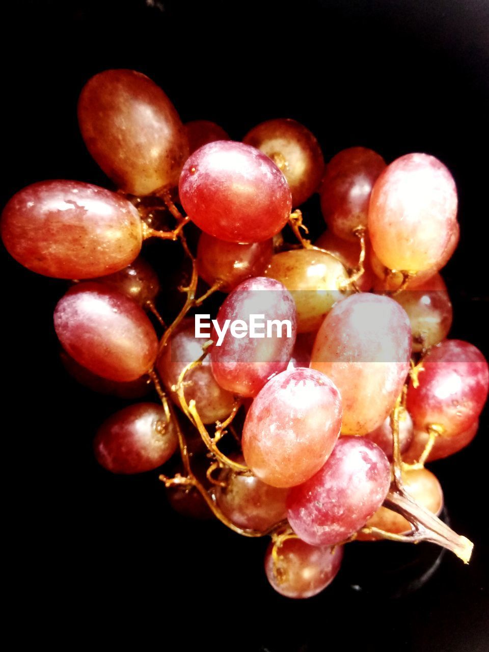 CLOSE-UP OF CHERRIES IN BLACK BACKGROUND