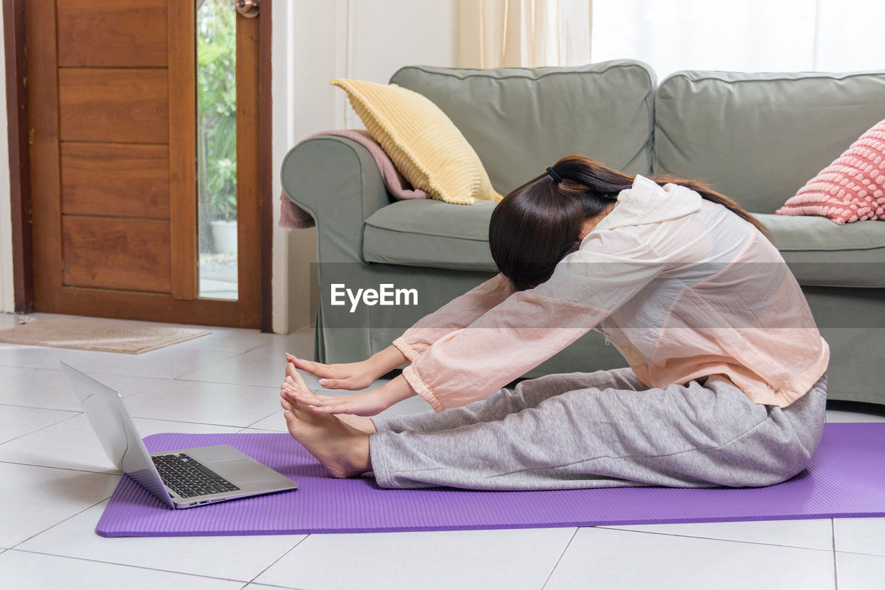 high angle view of young woman using laptop on bed at home