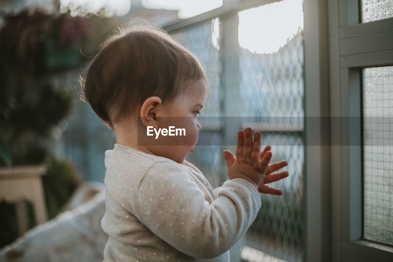 Side view of cute baby girl standing outdoors