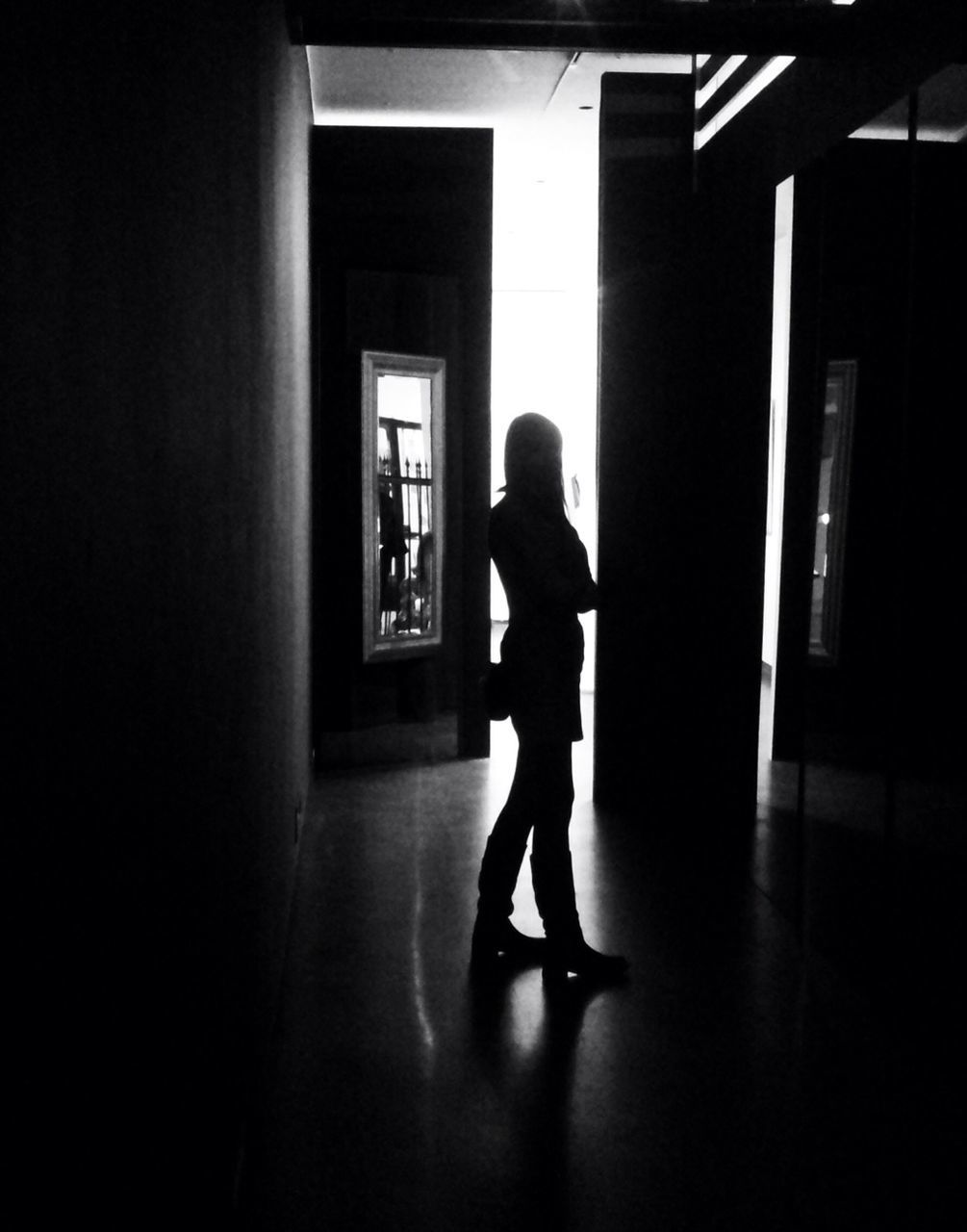 Silhouette woman standing in dark room