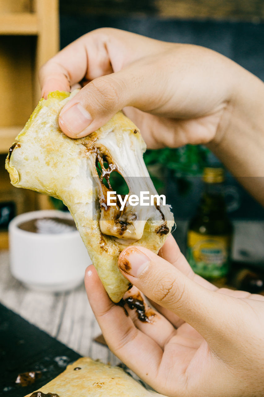 CLOSE-UP OF PERSON HAND HOLDING FOOD