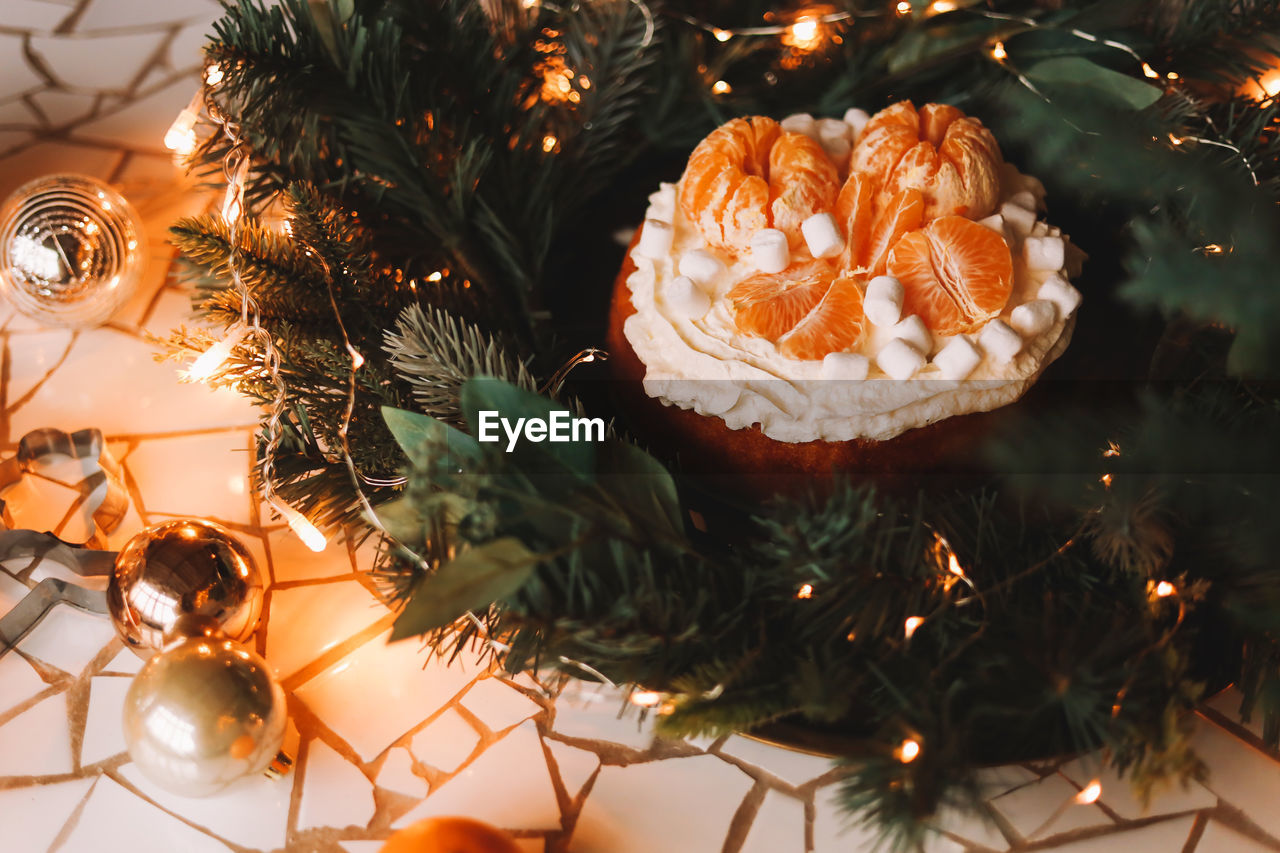 Christmas background. christmas food. cakedecorated with tangerines and fir branches in the holidays