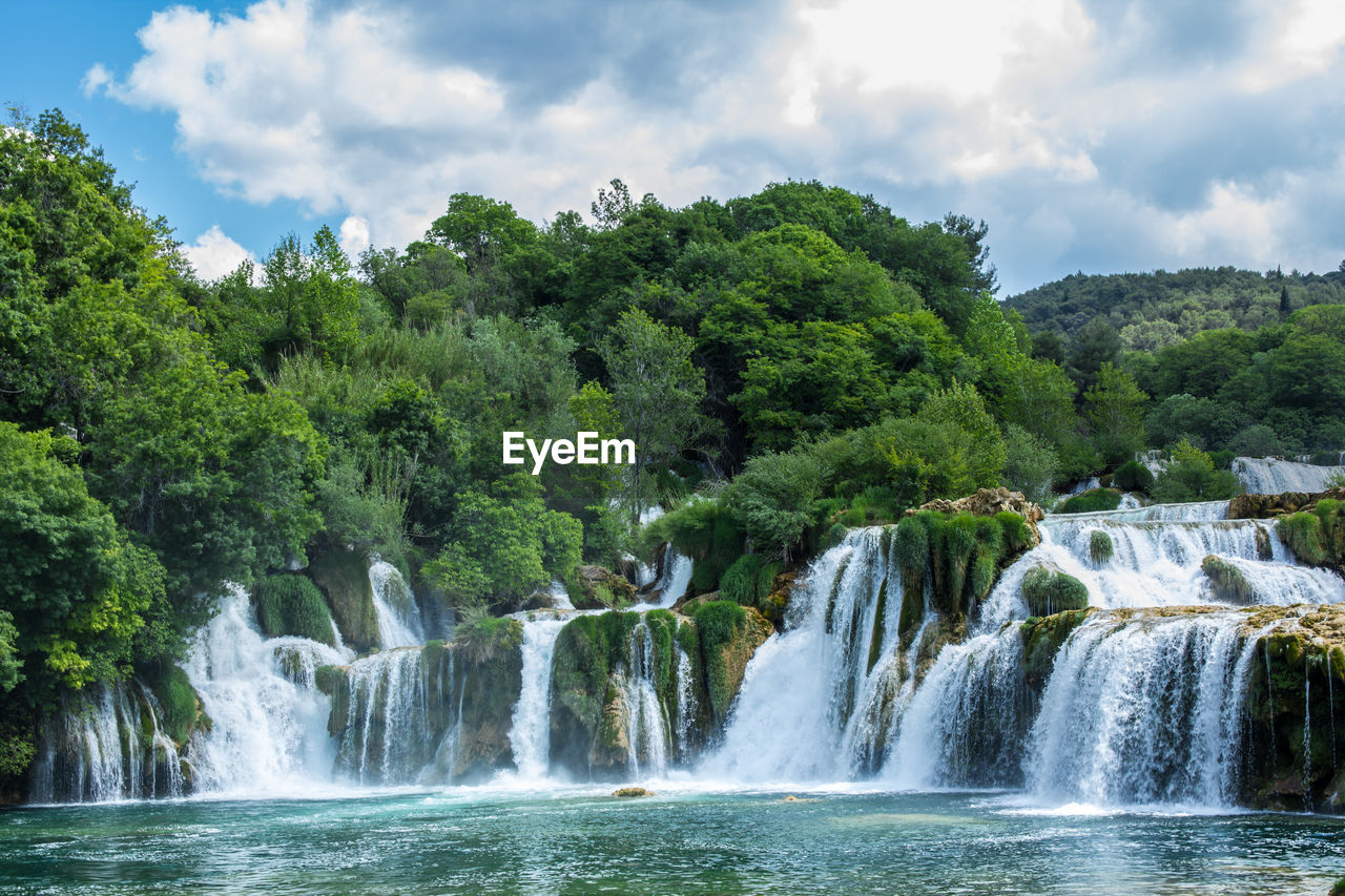 Scenic view of waterfall against sky