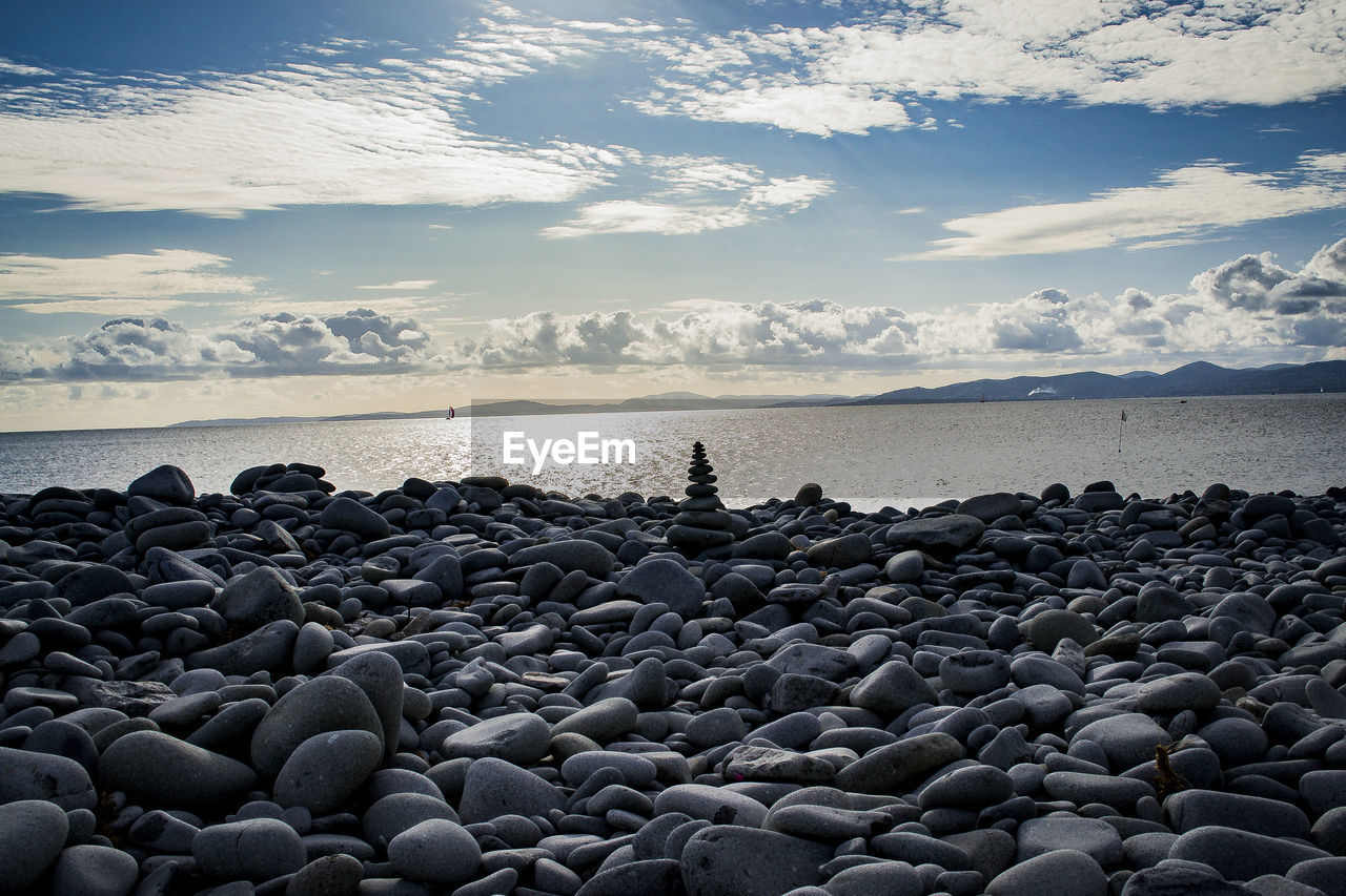 water, sky, sea, horizon, shore, beach, ocean, rock, land, nature, coast, cloud, beauty in nature, wave, scenics - nature, pebble, stone, tranquility, tranquil scene, horizon over water, body of water, environment, sand, outdoors, travel destinations, reflection, travel, landscape, morning, coastline, non-urban scene, seascape, holiday, idyllic, trip, day, vacation