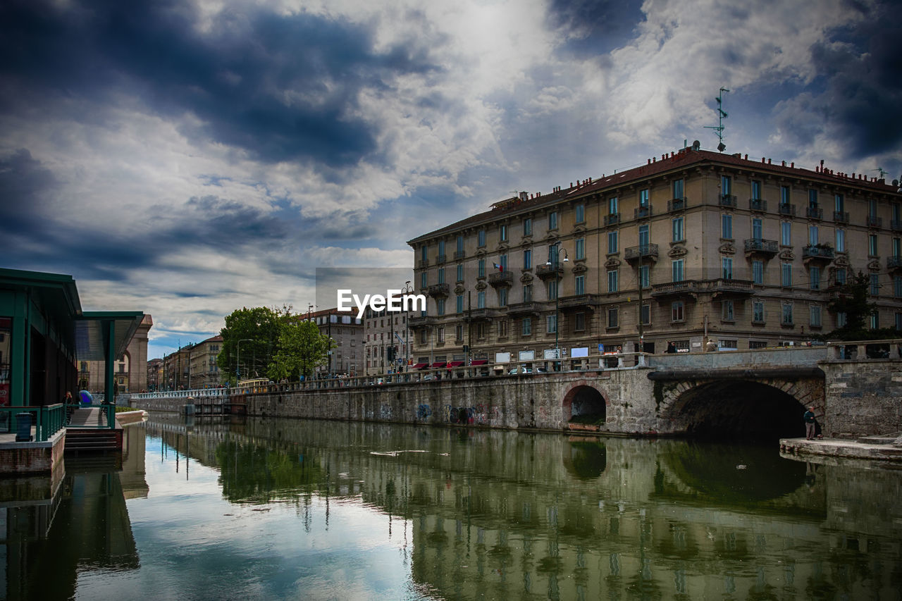 Bridge over river against cloudy sky