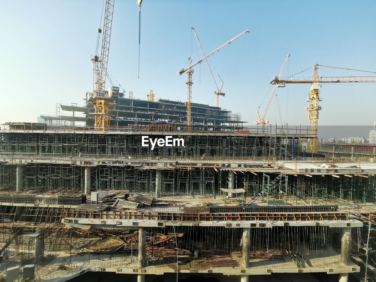 Cranes at construction site against sky in city