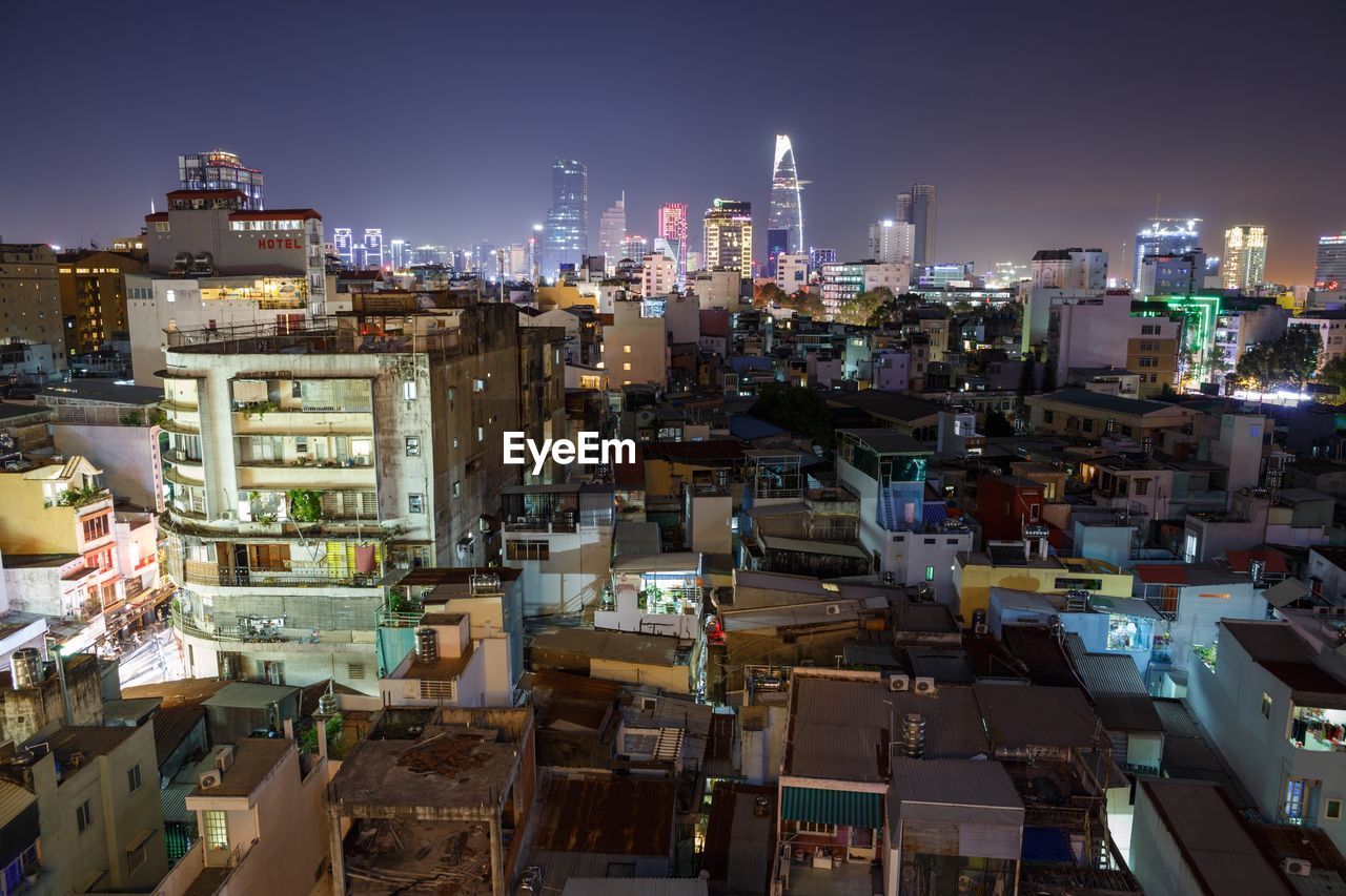 ILLUMINATED CITYSCAPE AGAINST SKY