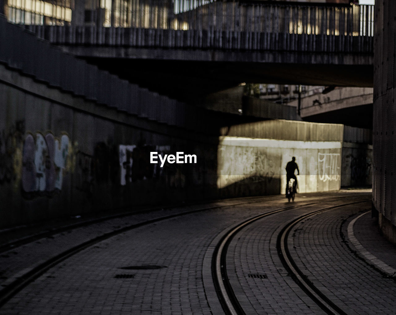 REAR VIEW OF PERSON WALKING ON RAILROAD TRACK