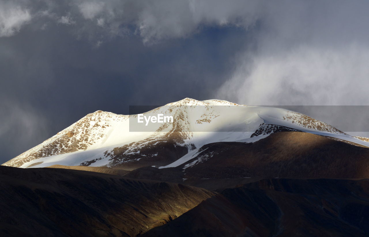 CLOSE-UP OF SNOW AGAINST MOUNTAIN