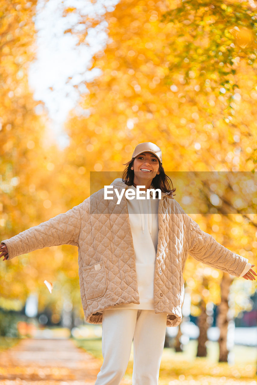 Portrait of smiling woman standing at park