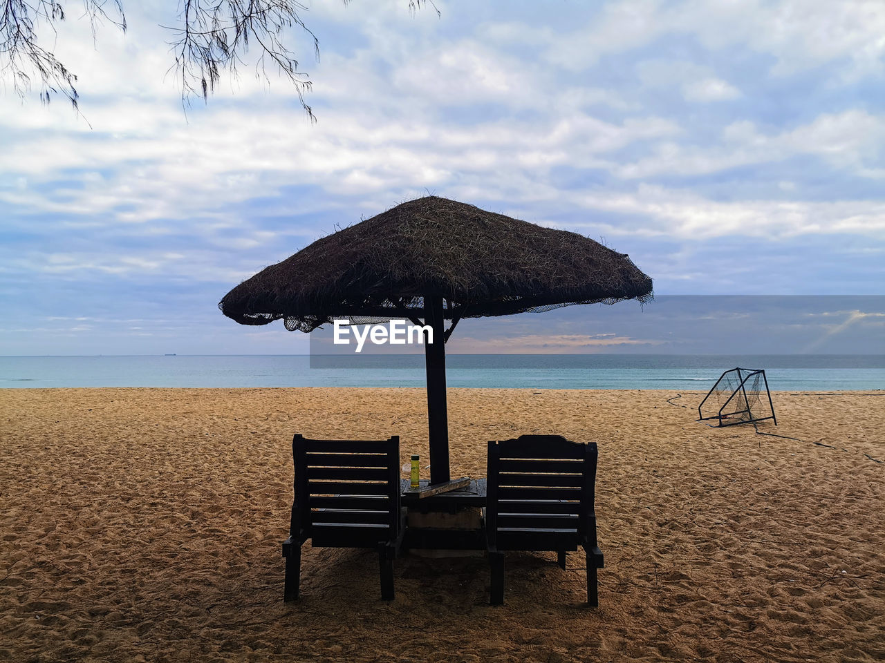 DECK CHAIRS ON BEACH AGAINST SKY