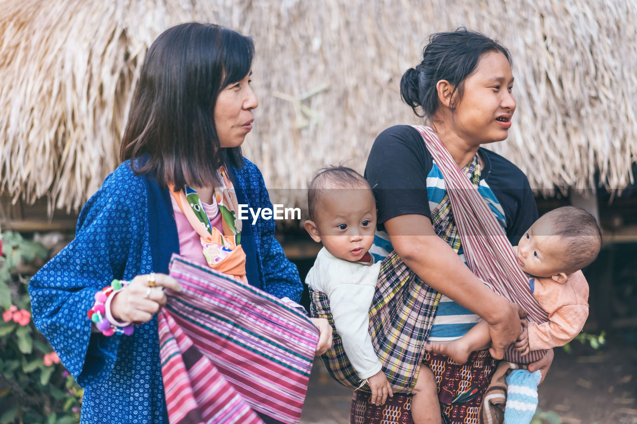 FULL LENGTH OF MOTHER AND DAUGHTER IN TRADITIONAL CLOTHING