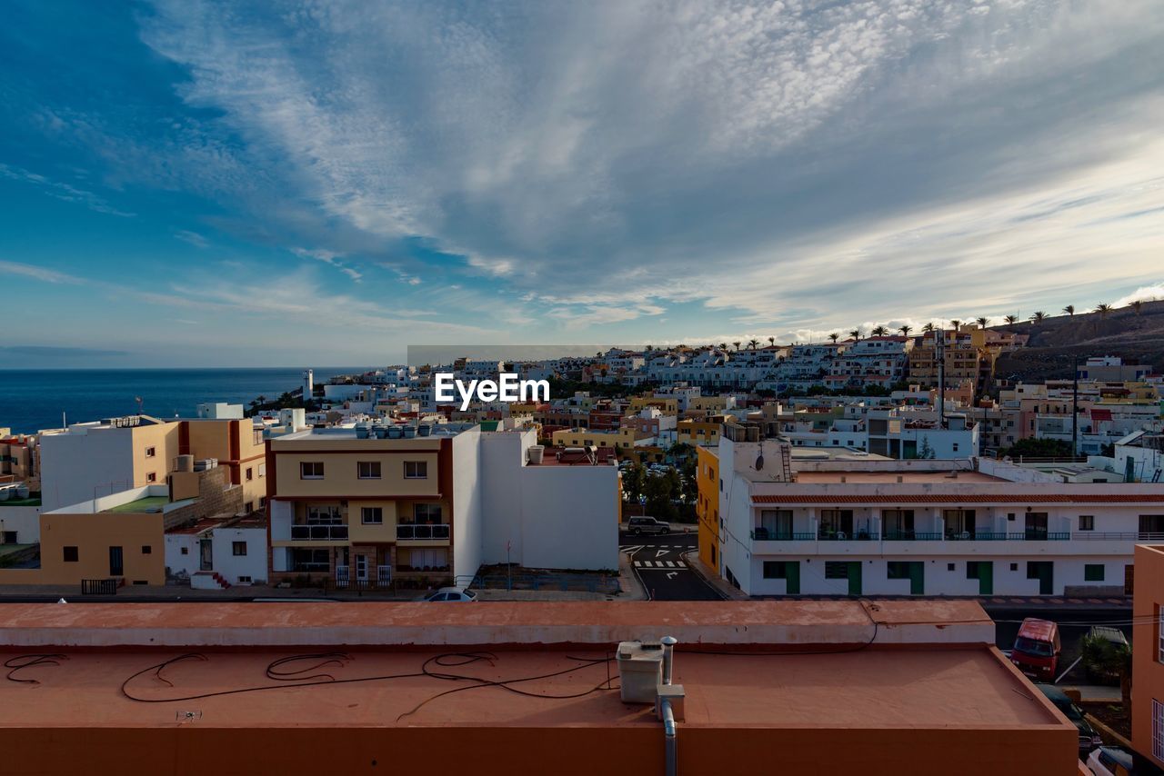 High angle view of townscape by sea against sky