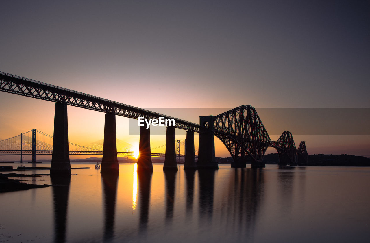 architecture, water, bridge, built structure, transportation, sky, dusk, reflection, sunset, evening, travel destinations, nature, sea, twilight, city, horizon, night, travel, beauty in nature, scenics - nature, railway bridge, engineering, cantilever bridge, long exposure, steel, alloy, business finance and industry, landscape, outdoors, dramatic sky, tranquility, rail transportation, industry, copy space, pier, tourism, architectural column, environment, fog, business, beach, metal, silhouette, tranquil scene, panoramic, mode of transportation, construction industry, idyllic, urban skyline, building exterior, bay, illuminated, bay of water, water's edge, cityscape, seascape, man made, moody sky