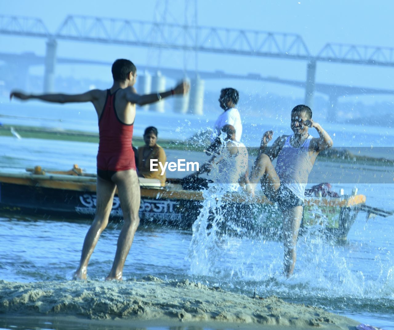 PEOPLE IN SWIMMING POOL AGAINST SEA