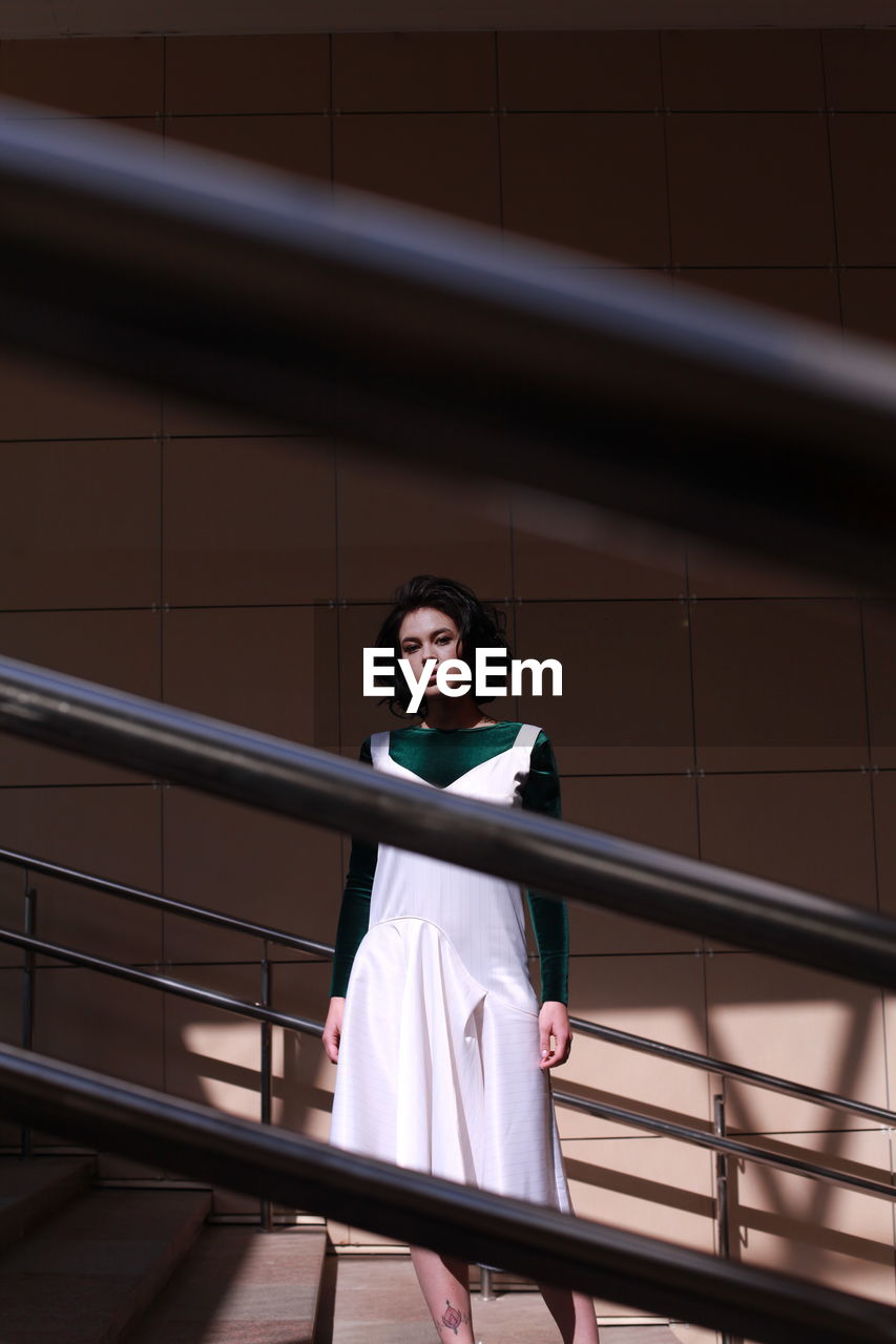 Portrait of beautiful young woman standing on steps