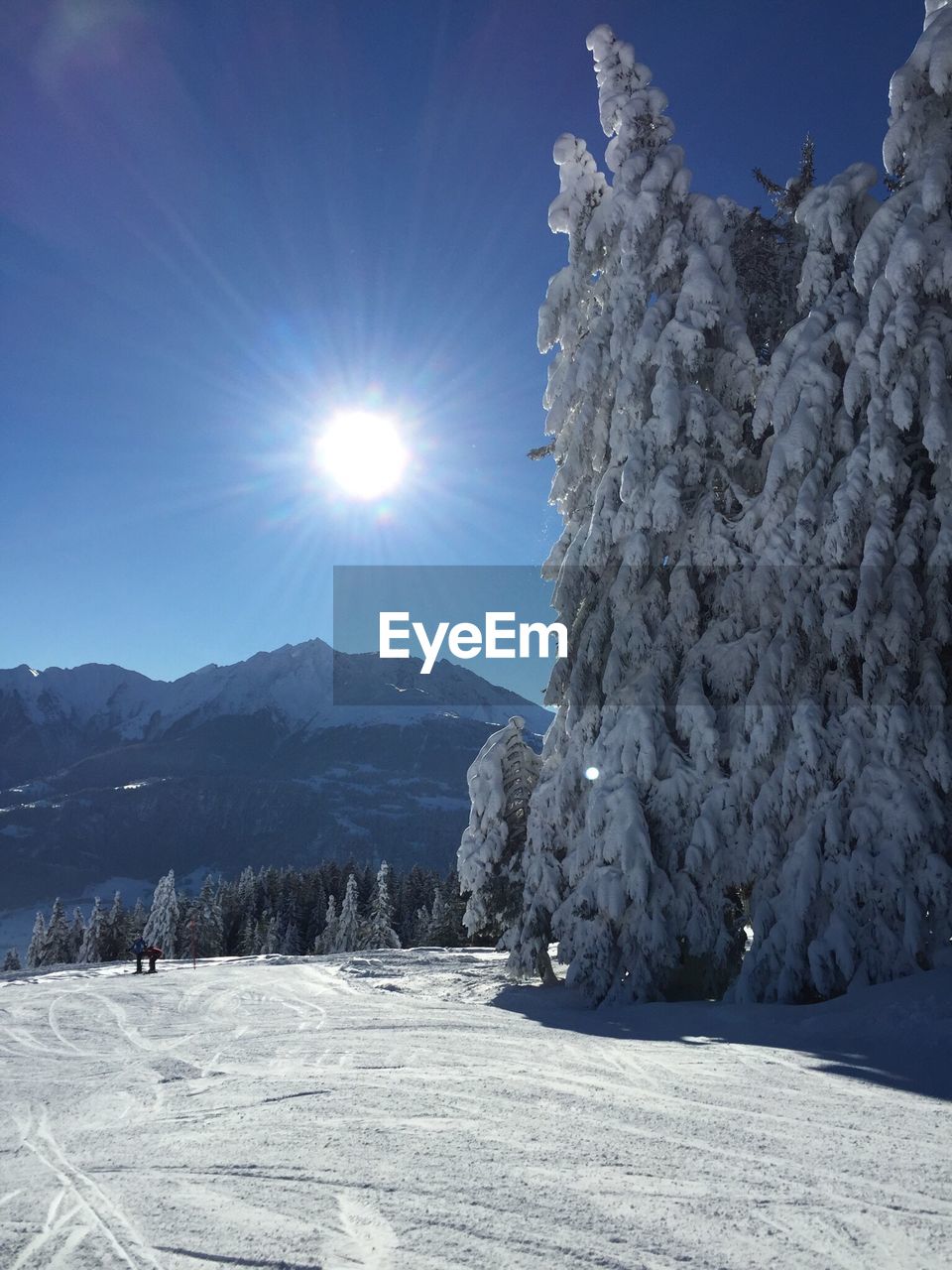 Scenic view of snowcapped mountains against sky on sunny day